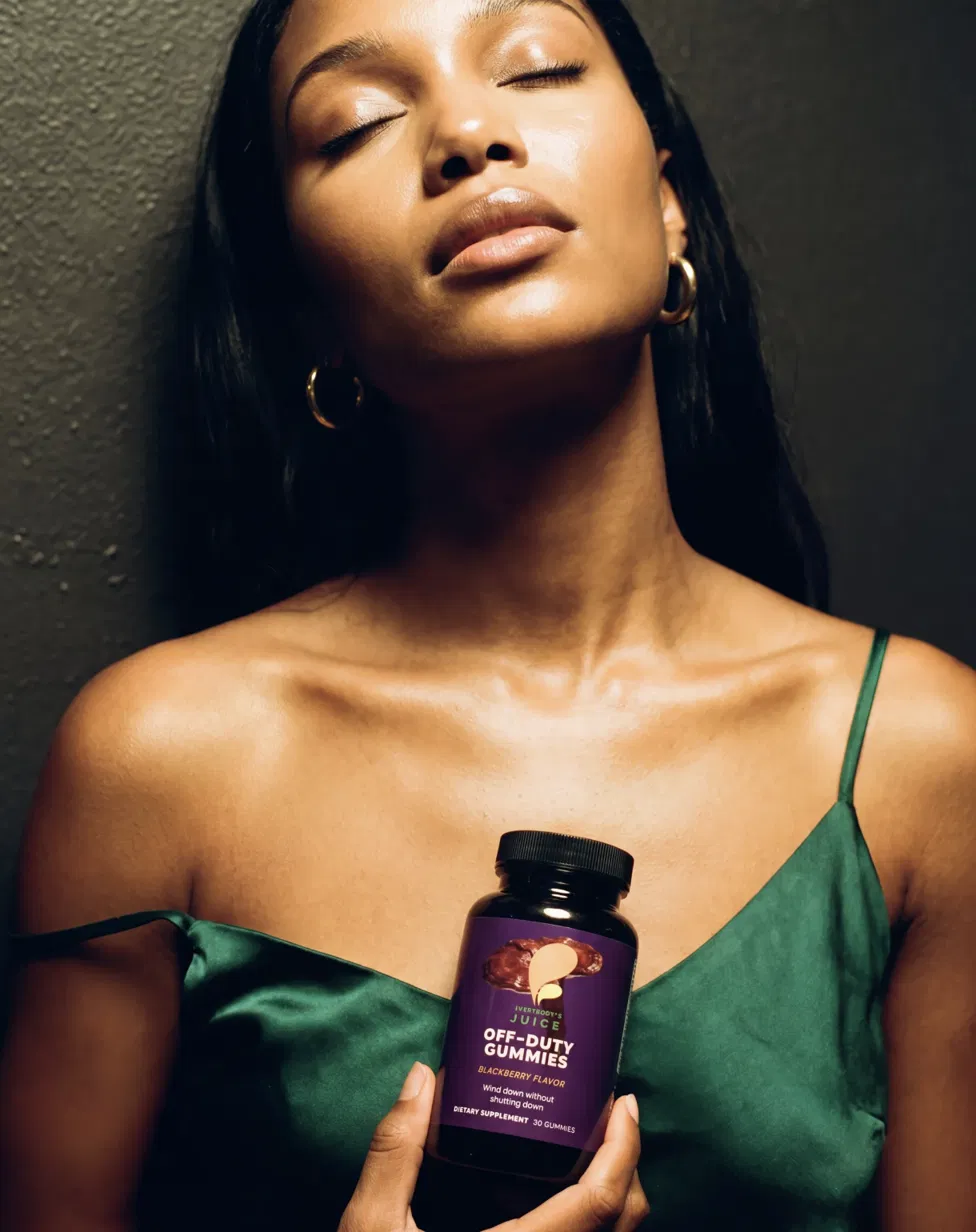 Woman in green silk, eyes closed, holding Off-Duty bottle